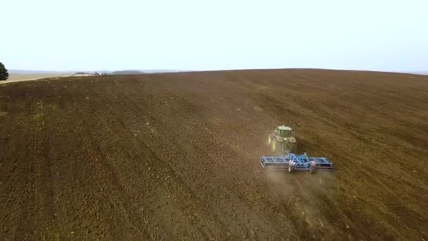 秋に収穫した黒田を耕すトラクターの空中映像 — ストック動画