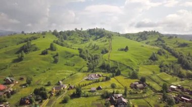 Yazın Ukrayna 'nın Ukrayna Dağları' ndaki yeşil yaz tepeleri arasında küçük bir köyün havadan görünüşü.