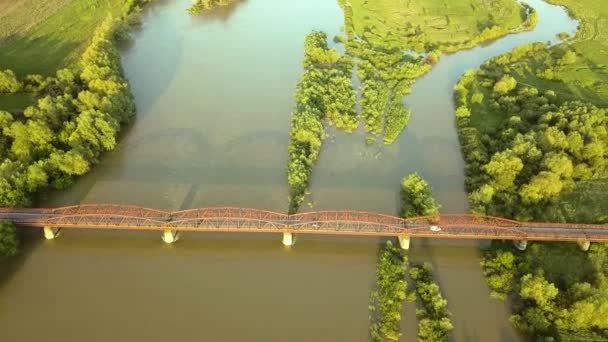 绿色农村地区泥泞宽阔河流上一座狭窄桥梁的空中景观 — 图库视频影像