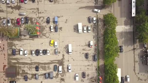 有停放车辆的停车场和有流动车辆的街道以及有过路行人的斑马人行横道的空中俯瞰 — 图库视频影像