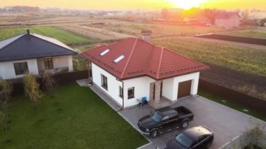 Arka bahçesinde park etmiş arabaları olan özel bir banliyö evinin havadan görüntüsü..