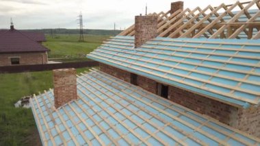 Ahşap çatı iskeleti olan tuğladan bir evin havadan görünüşü.