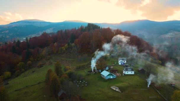日落时在乌克兰喀尔巴阡山脉秋林间的广袤草甸上 鸟瞰遥远的村庄 那里有小牧羊人的房子 — 图库视频影像