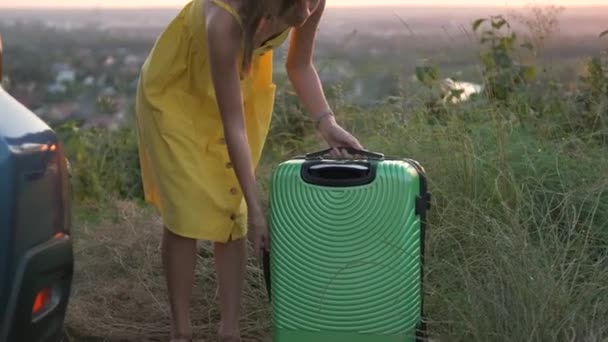 Jovem Mulher Vestido Amarelo Colocando Mala Verde Porta Malas Carro — Vídeo de Stock