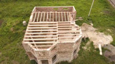 Ahşap tavan çerçeveli tuğladan bir evin havadan görünüşü.