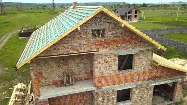 Aerial view of a brick house with wooden roof frame under construction. — Stock Footage Aerial View Brick House Wooden Roof Frame Construction Stock Video
