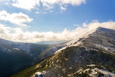 Sonbahar ladin ormanları ve yüksek karlı zirvelerle kaplı yüksek dağ zirveleri.