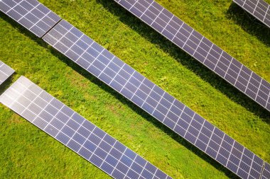 Yeşil alandaki güneş enerjisi santralinin havadan görüntüsü. Temiz ekolojik enerji üretmek için elektrik panelleri.