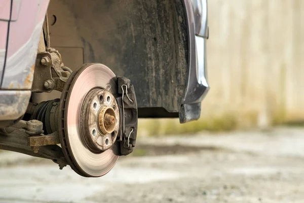 新しいタイヤ交換の過程で修理のためのブレーキキャリパーと車両のブレーキディスクの閉鎖 ガレージでのブレーキ修理 — ストック写真