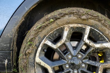 Sarı çamurla kaplı kirli lastikleri olan kirli off-road araba tekerleklerini kapatın..