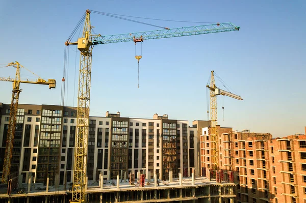 High multi storey residential apartment buildings under construction. Concrete and brick framing of high rise housing. Real estate development in urban area.