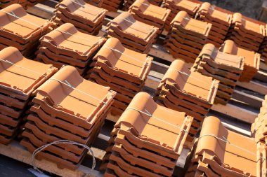 İnşaat halindeki binanın çatısını kaplamak için sarı seramik kiremitler..