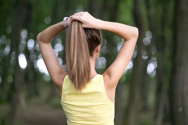 Młoda Kobieta Wiąże Długie Włosy Stojąc Zewnątrz — Zdjęcie stockowe