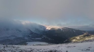 Soğuk kış havasında karlı dağ tepelerinin havadan görünüşü.