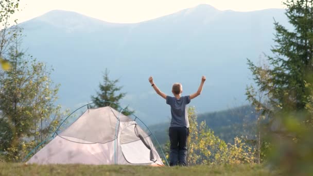 Szczęśliwy Chłopiec Skacze Wysoko Podniesionymi Rękami Pobliżu Namiotu Kempingowego Górach — Wideo stockowe