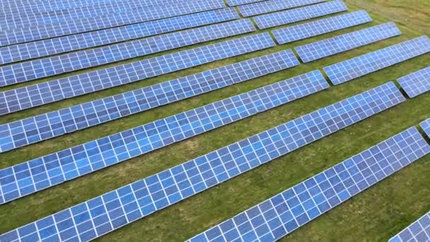 緑のフィールド上の太陽光発電所の空中ビュー クリーンな生態エネルギーを生産するための電気パネル — ストック動画