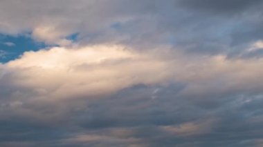 Mavi gökyüzünde hızla hareket eden bulutlarla birlikte zaman akışı.