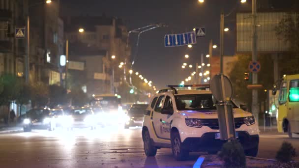 Blått Blinkende Lys Politipatruljebil Parkert Byens Gate Med Natttrafikk – stockvideo
