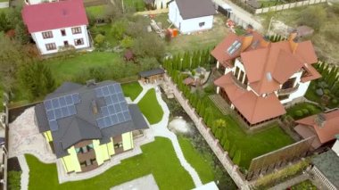 Çatıda temiz elektrik üretmek için güneş fotovoltaik panelleri olan kırsal bir özel evin havadan görünüşü. Özerk konut kavramı.