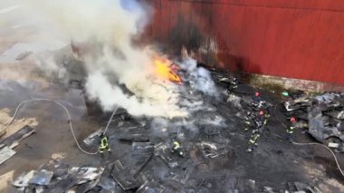 Sanayi bölgesinde eski fabrika yakınlarında ateşle savaşan itfaiyecilerin hava görüntüsü..