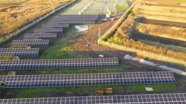 Yeşil alanda inşa halindeki güneş enerjisi santralinin havadan görüntüsü. Temiz ekolojik enerji üretimi için elektrik panellerinin montajı.