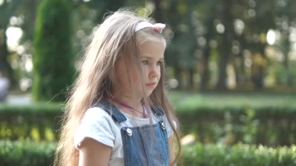 Счастливая Маленькая Девочка Играет Своей Любимой Игрушкой Плюшевого Медведя Улице — стоковое видео