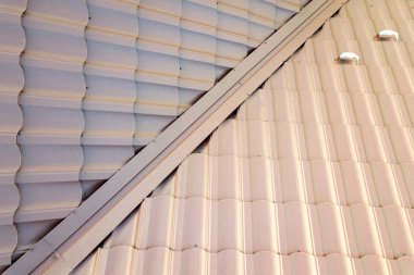 Kahverengi metal kiremit levhalarla kaplı evin detaylı görüntüsü.