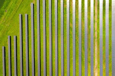 Yeşil alandaki güneş enerjisi santralinin havadan görüntüsü. Temiz ekolojik enerji üretmek için elektrik panelleri.