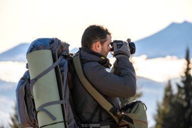 Sırt çantalı fotoğrafçı dijital fotoğraf makinesiyle doğanın fotoğraflarını çekiyor..