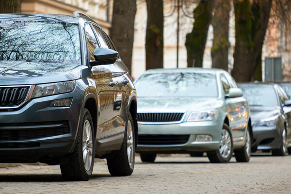 Cars parked in a row on a city street side.