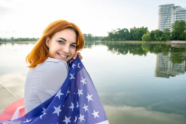 Szczęśliwie Uśmiechnięta Młoda Kobieta Flagą Narodową Usa Ramionach Wysokimi Budynkami — Zdjęcie stockowe