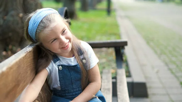 Küçük Mutlu Kız Çocuğu Yaz Parkında Mutlu Bir Şekilde Bankta — Stok fotoğraf