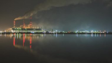 Kömür santralinin zaman aşımı. Siyah dumanlı yüksek borular. Gece atmosferi kirletiyor..