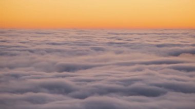 Gün batımında sarı vadide hızla hareket eden sisli bulutlar..