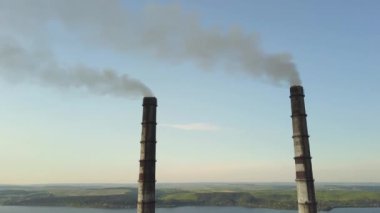 Kömür santralinden gelen gri dumanlı uzun baca borularının hava manzarası. Fosil yakıtla elektrik üretimi.