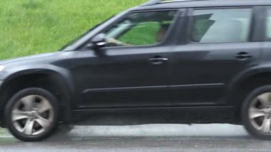 Arabalar hızlı gidiyor. Su basmış yollara kirli yağmur suyu püskürtüyor..