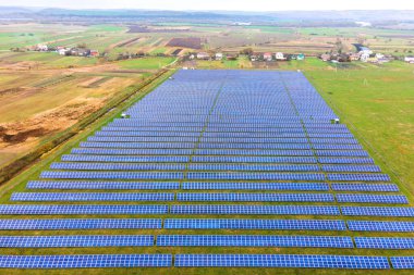 Yeşil alandaki güneş enerjisi santralinin havadan görüntüsü. Temiz ekolojik enerji üretmek için panelleri olan elektrik çiftliği.