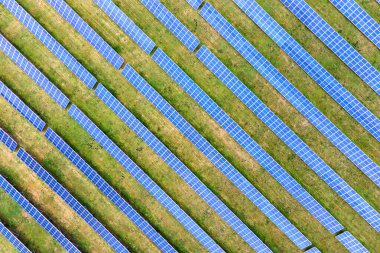 Yeşil alandaki güneş enerjisi santralinin havadan görüntüsü. Temiz ekolojik enerji üretmek için panelleri olan elektrik çiftliği.