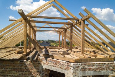 İnşaat halindeki ahşap çatı iskeleti olan bitmemiş evin havadan görünüşü.
