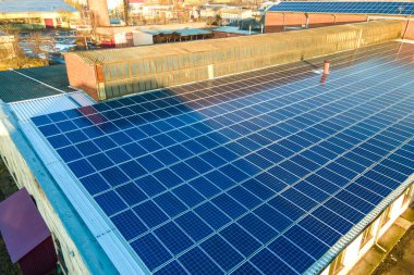 Mavi fotovoltaik güneş panelleri endüstriyel binaların çatısına temiz ekolojik elektrik üretmek için monte edildi. Yenilenebilir enerji konsepti üretimi.