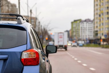 Şehrin sokaklarında park edilmiş yeni temiz bir arabanın arka farının yakın çekimi..