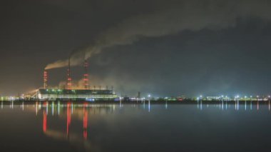 Kömür santralinin zaman aşımı. Siyah dumanlı yüksek borular. Gece atmosferi kirletiyor..