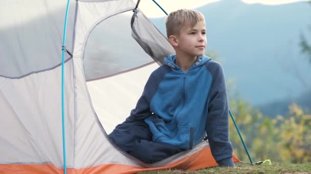 美しい夏の自然の景色を楽しむ山のキャンプ場の観光テントで休んで幸せな子供の男の子 ハイキングと生活の概念の積極的な方法 — ストック動画