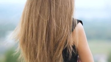 Açık havada hafif rüzgârda sallanan serbest kadın saçlarının yakın çekimi..
