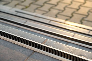 Verandadaki merdivenleri kaplayan seramik karoların üzerinde lastik kaygan çizgiler var..