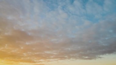 Gün batımında mavi gökyüzünde hızla hareket eden bulutlarla birlikte zaman akıp gidiyor..