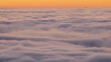 Gün batımında sarı vadide hızla hareket eden sisli bulutlar..