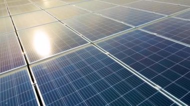 Temiz ekolojik elektrik üretmek için çatıya monte edilen mavi fotovoltaik güneş panellerinin havadan görünüşü. Yenilenebilir enerji konsepti üretimi.