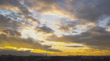 Gün batımında koyu mavi gökyüzünde hızlı hareket eden bulutların zaman akışı.