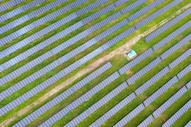 Yeşil alandaki güneş enerjisi santralinin havadan görüntüsü. Temiz ekolojik enerji üretmek için elektrik panelleri.